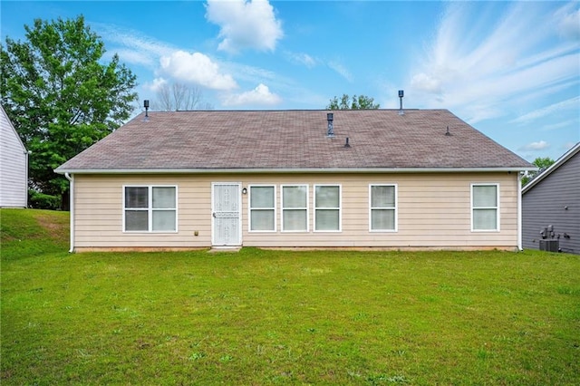 rear view of property with a yard, a shingled roof, and cooling unit
