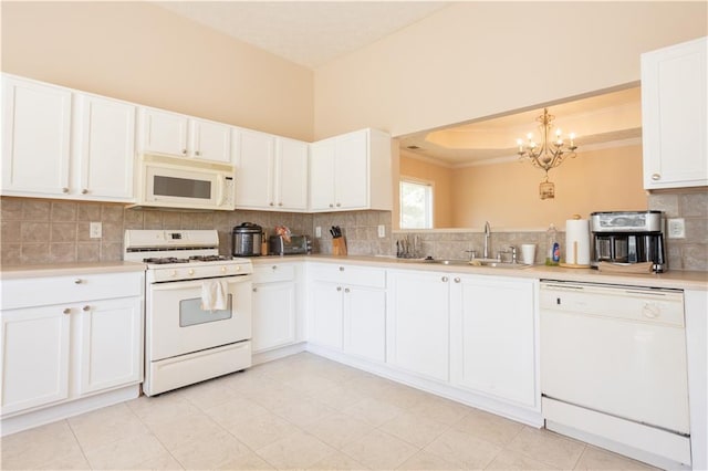 kitchen with white appliances, a sink, a chandelier, light countertops, and tasteful backsplash