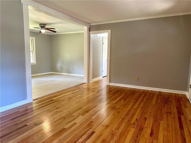 empty room featuring ceiling fan, light wood-type flooring, and ornamental molding