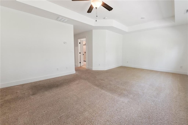 spare room featuring carpet flooring, ceiling fan, and a raised ceiling