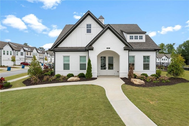 view of front of property featuring french doors and a front lawn