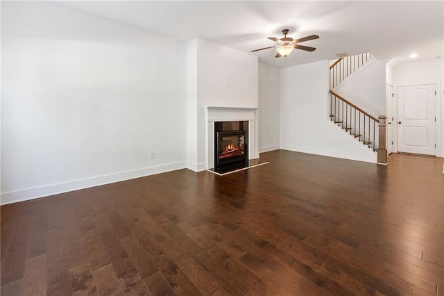 unfurnished living room featuring ceiling fan and dark hardwood / wood-style floors