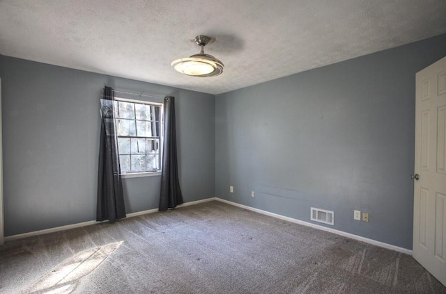 unfurnished room with a textured ceiling and carpet flooring