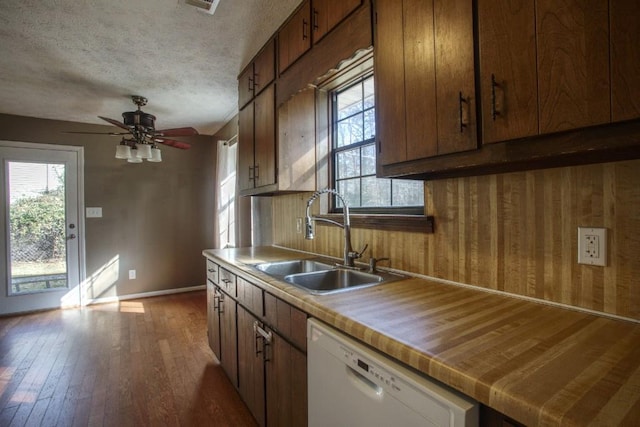 kitchen with ceiling fan, dishwasher, dark hardwood / wood-style floors, sink, and a textured ceiling