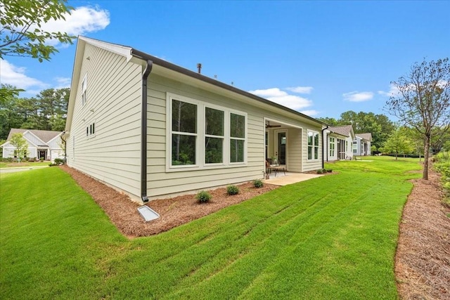 back of house featuring a lawn and a patio area