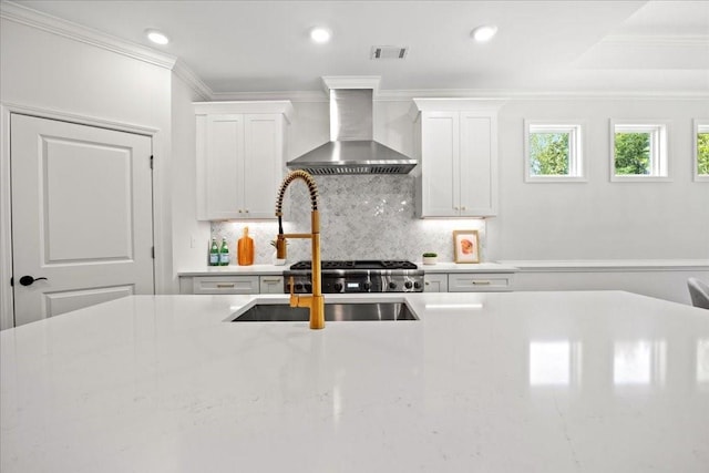 kitchen featuring sink, crown molding, wall chimney range hood, decorative backsplash, and white cabinets