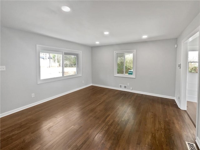 unfurnished room featuring dark hardwood / wood-style flooring and a wealth of natural light