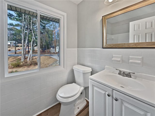 bathroom featuring vanity, wood-type flooring, tile walls, and toilet