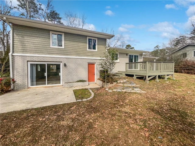 back of house featuring a wooden deck, a yard, and a patio area