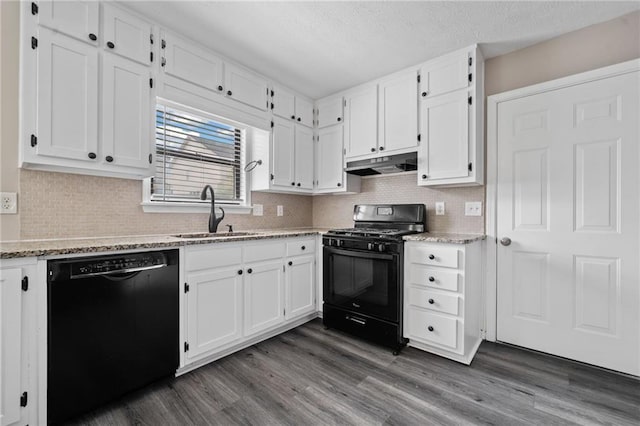 kitchen with white cabinets, a sink, dark wood finished floors, under cabinet range hood, and black appliances