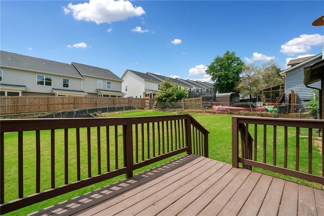 wooden terrace with a lawn, a residential view, and a fenced backyard