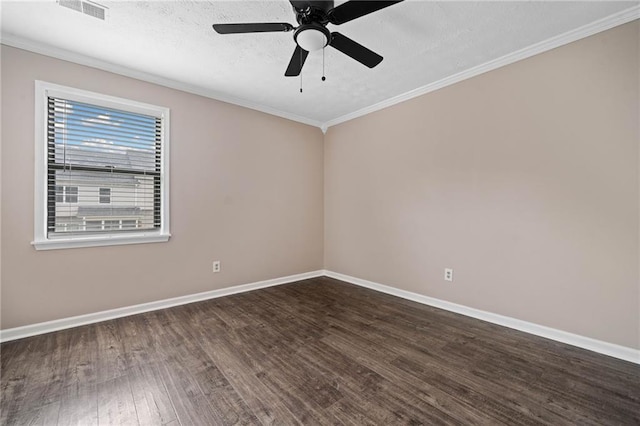 spare room with visible vents, crown molding, wood finished floors, baseboards, and ceiling fan