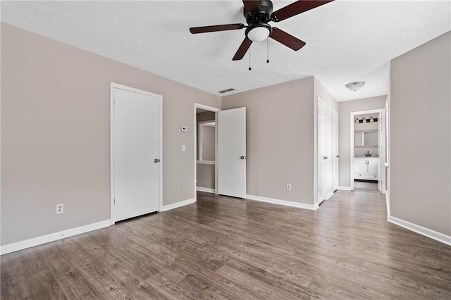 interior space with visible vents, a ceiling fan, baseboards, and wood finished floors