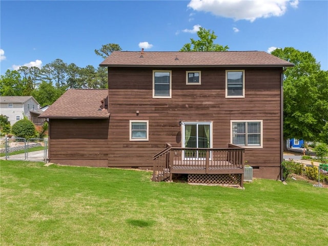 back of house featuring a lawn, fence, a gate, and a deck