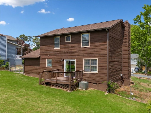 back of property with fence, a shingled roof, a deck, cooling unit, and a lawn