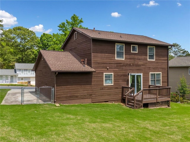 back of house with a wooden deck, a gate, fence, a yard, and a shingled roof