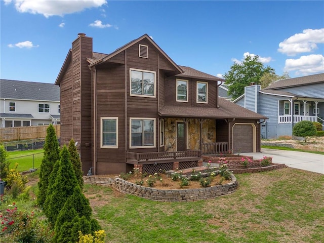 view of front of house featuring a front lawn, fence, a chimney, a porch, and driveway