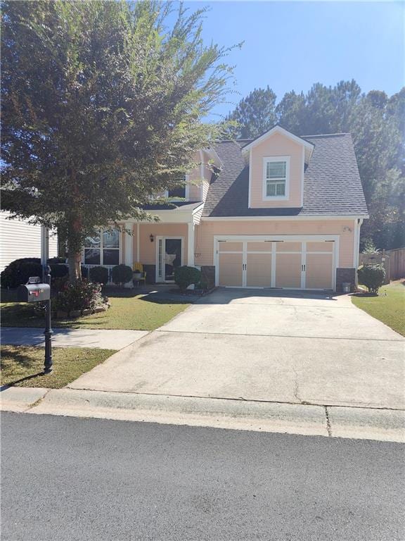 view of front of house featuring a front lawn and a garage