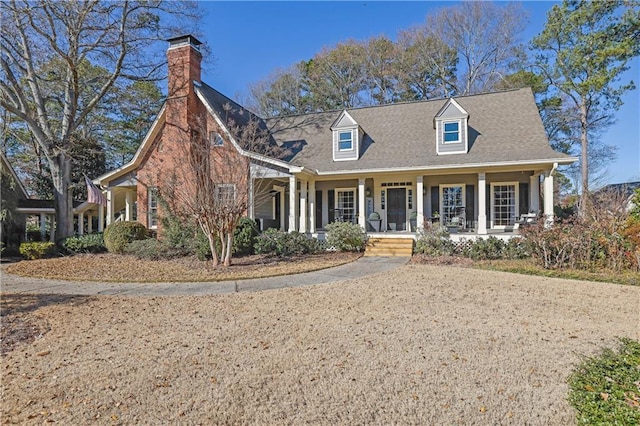 cape cod house featuring covered porch