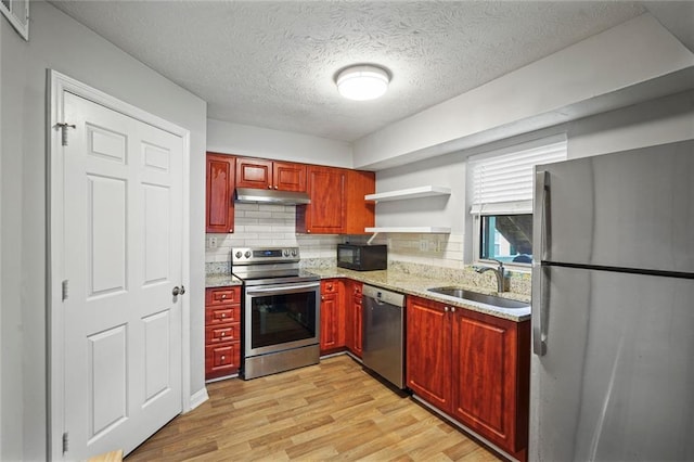 212 Brittany Ct, Duluth, GA 30096 - kitchen with stainless steel appliances, a sink, light wood finished floors, backsplash, and a textured ceiling