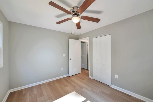 unfurnished bedroom with ceiling fan, light wood-type flooring, and a closet