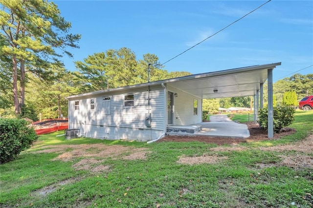 rear view of property featuring a yard and a carport