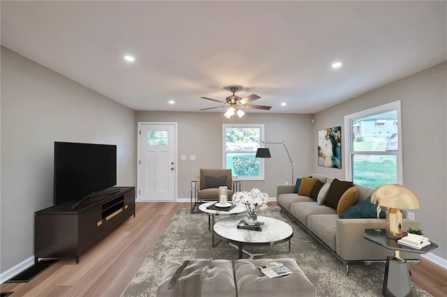 living room with light hardwood / wood-style flooring and ceiling fan