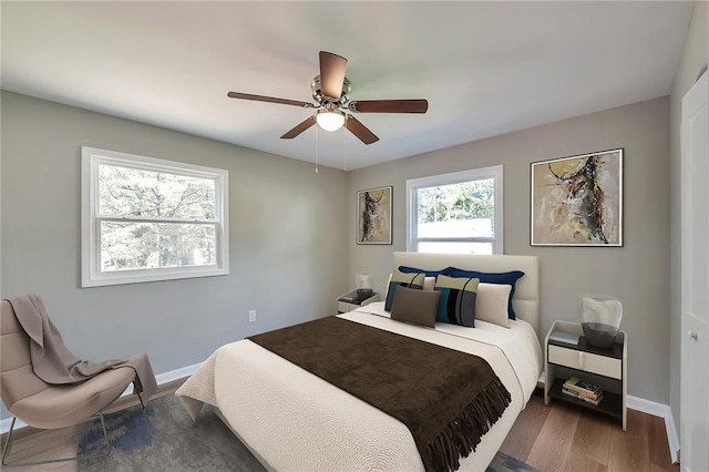 bedroom featuring wood-type flooring, multiple windows, and ceiling fan