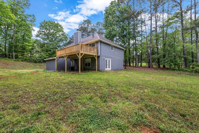 back of house featuring central AC, a deck, french doors, a chimney, and a lawn