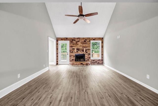 unfurnished living room with ceiling fan, high vaulted ceiling, baseboards, and wood finished floors