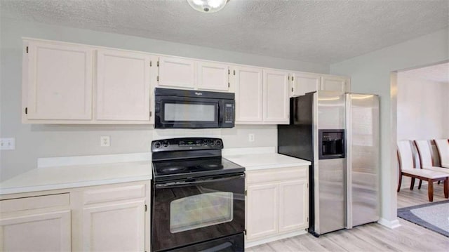 kitchen with black appliances, white cabinets, and a textured ceiling