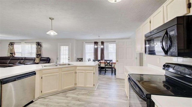 kitchen featuring pendant lighting, black appliances, and plenty of natural light