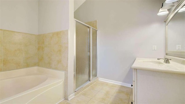 bathroom featuring plus walk in shower, vanity, and tile patterned flooring