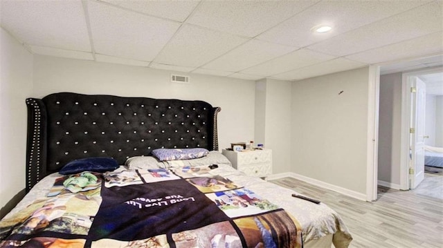 bedroom featuring hardwood / wood-style flooring and a paneled ceiling