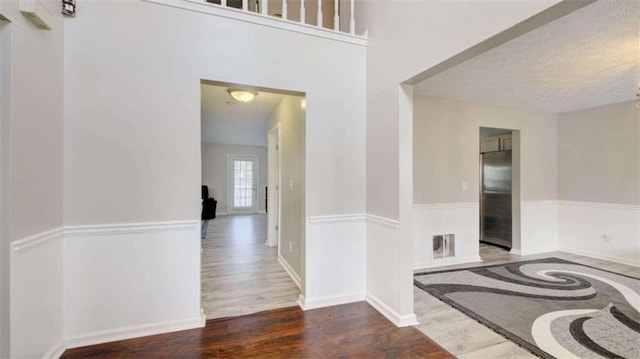 hall featuring a textured ceiling and dark hardwood / wood-style floors