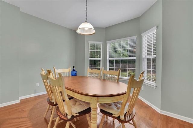 dining space with baseboards and wood finished floors