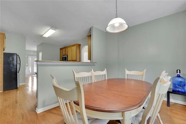 dining room featuring baseboards and light wood-style floors