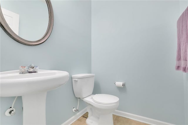 bathroom with baseboards, a sink, tile patterned floors, and toilet