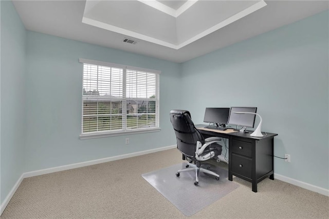 carpeted office space featuring baseboards, visible vents, and a raised ceiling