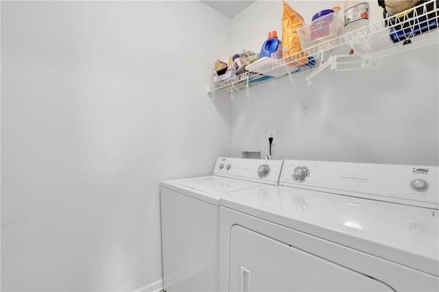 clothes washing area with washing machine and clothes dryer, laundry area, and baseboards