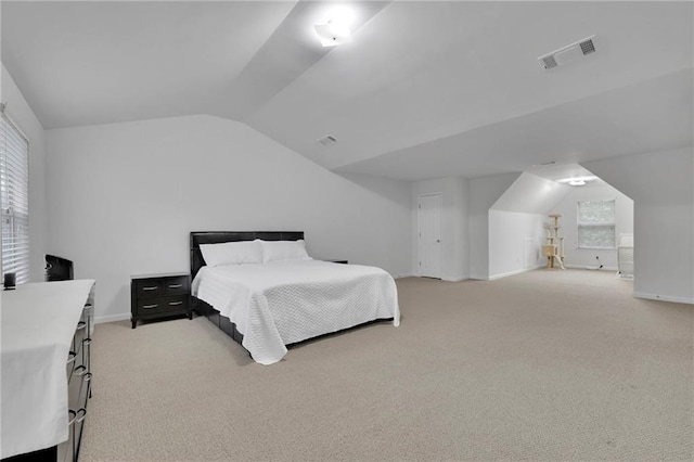 bedroom with light colored carpet, visible vents, multiple windows, and lofted ceiling
