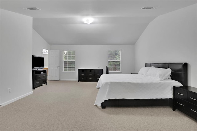bedroom with visible vents, baseboards, vaulted ceiling, and light carpet