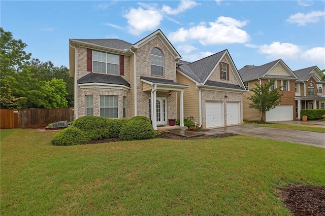 traditional-style home with brick siding, an attached garage, fence, and aphalt driveway