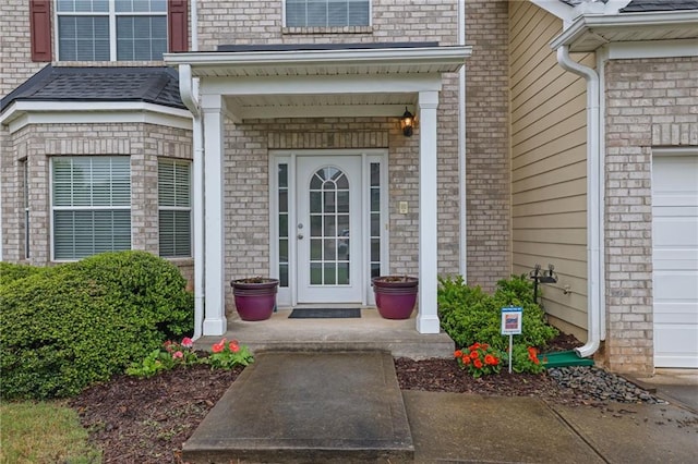 view of exterior entry featuring brick siding