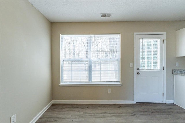 entryway featuring light hardwood / wood-style floors and a textured ceiling