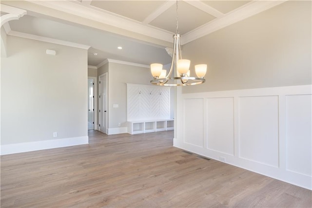 unfurnished room with ornamental molding, beam ceiling, a chandelier, and light hardwood / wood-style flooring