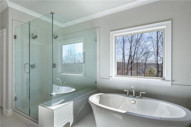 bathroom with a wealth of natural light, ornamental molding, and independent shower and bath