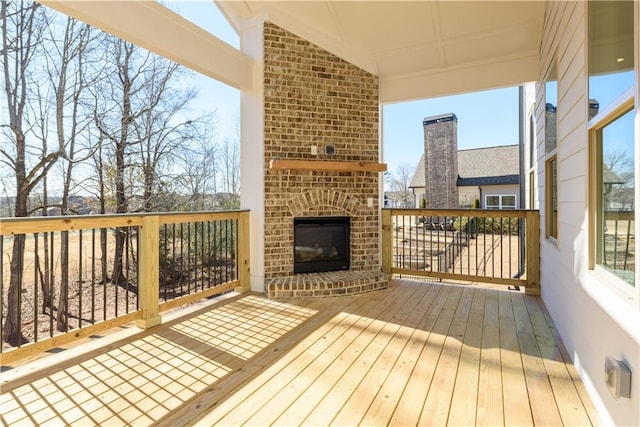 wooden deck featuring an outdoor brick fireplace