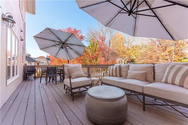 wooden terrace with outdoor dining space and outdoor lounge area