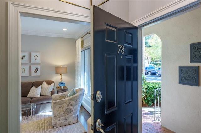 entrance foyer featuring crown molding and brick floor